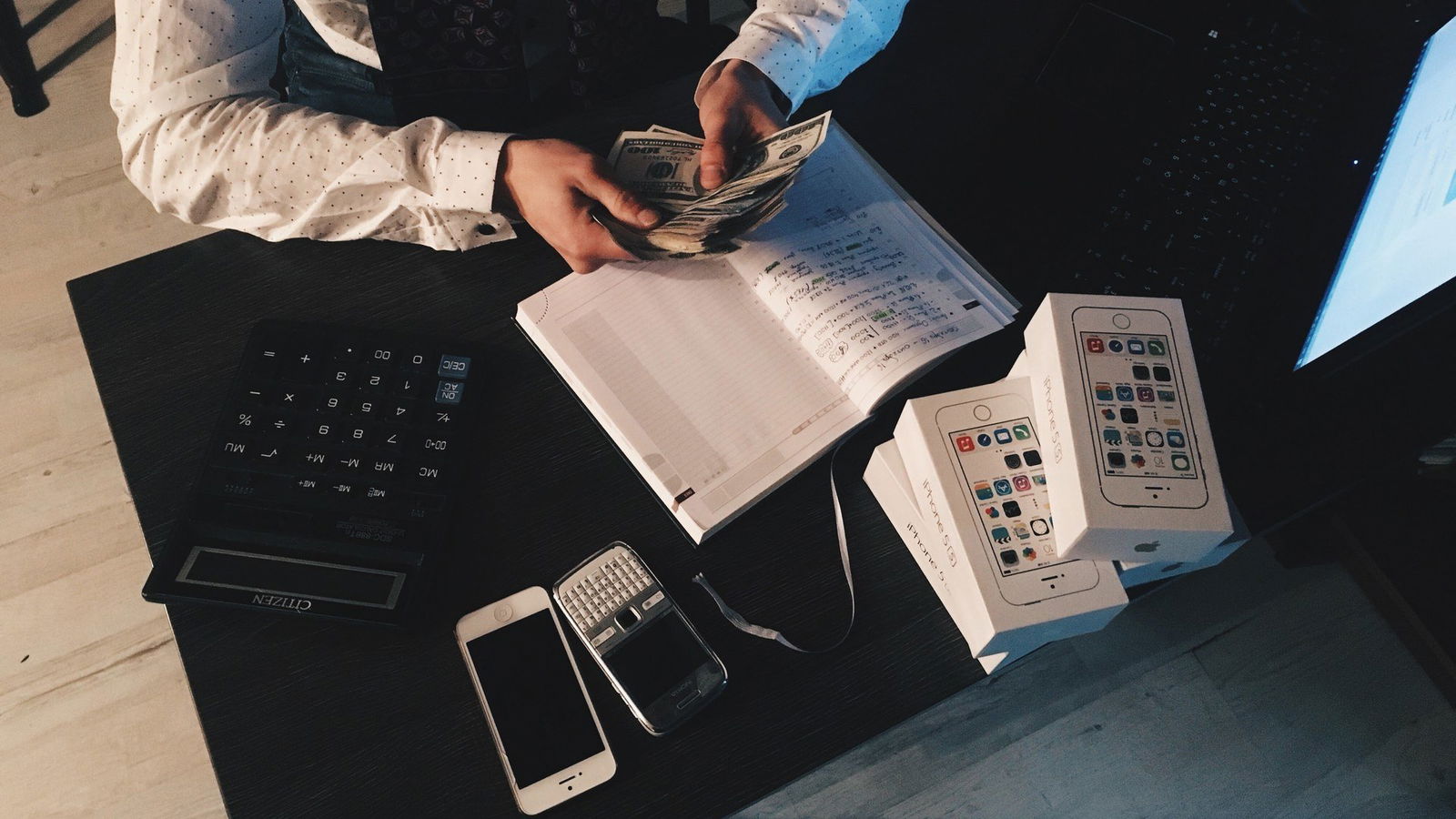 Mann an Tisch zählt Geld